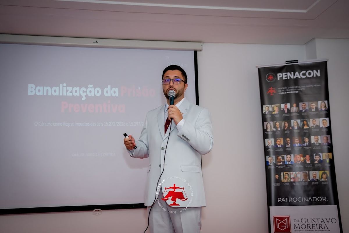 Palestrante com o banner de patrocinadores ao fundo na III PENACON